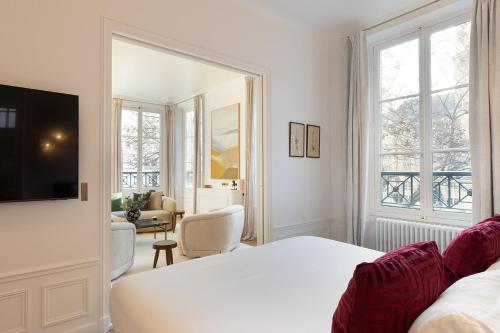 une chambre avec un lit blanc et un grand miroir dans l'établissement Pick A Flat's apartment in Saint-Germain - Place Furstemberg, à Paris