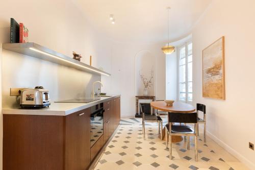 une cuisine avec un comptoir, une table et des chaises dans l'établissement Pick A Flat's apartment in Saint-Germain - Place Furstemberg, à Paris