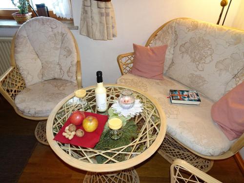 a table with a tray of fruit and a bottle of wine at Bärli in Bayersoien