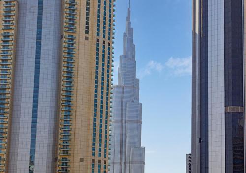 a group of tall buildings in a city at Nice 2 Bedroom Apartment! 5 Minute walk to Dubai Mall! Burj Khalifa View! in Dubai