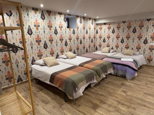 two beds in a room with floral wallpaper at Casa Jacinto in Orós Alto