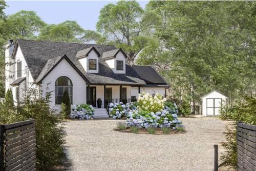 a white house with flowers in the driveway at Marys Gated Oasis Private Estate in Southampton