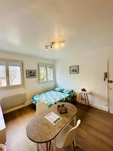 Una habitación con una cama y una mesa dentro. en Le Petit Gambetta, en Charleville-Mézières