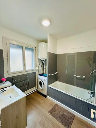 y baño con bañera y lavadora. en Le Petit Gambetta, en Charleville-Mézières