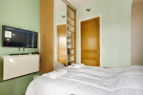 une chambre avec un lit blanc et une télévision à écran plat dans l'établissement 504 Suite Mozart - Superb apartment in Paris, à Paris