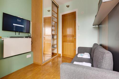 un salon avec un canapé et une télévision à écran plat dans l'établissement 504 Suite Mozart - Superb apartment in Paris, à Paris