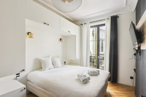 une chambre blanche avec un grand lit blanc et une fenêtre dans l'établissement 511 Suite Tour - Superb apartment in Paris, à Paris