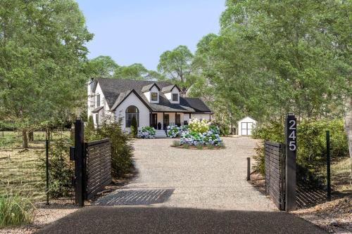 a white house with a gate and flowers at Marys Gated Oasis Private Estate in Southampton