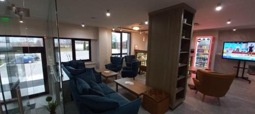 a waiting room with blue chairs and a television at New Wolf in Bran