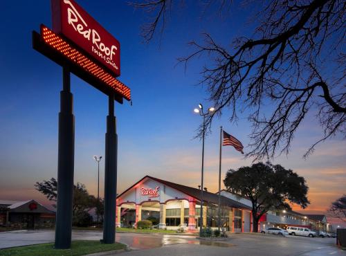 a fast food restaurant with a sign in a parking lot at Red Roof Inn & Suites Irving - DFW Airport South in Irving