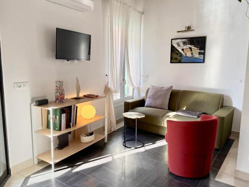 a living room with a couch and a red chair at Ca Penini - canal view in Venice