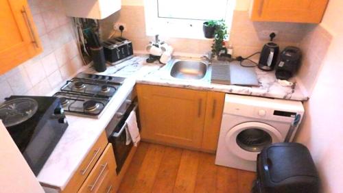 スラウにあるThe cozy condo sleeps 6 parkingの小さなキッチン(シンク、洗濯機付)