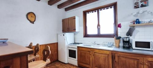 a kitchen with a stove and a white refrigerator at Un séjour à Foncine in Foncine-le-Haut