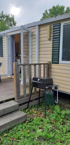 - un barbecue sur une terrasse à côté d'une maison dans l'établissement Mobil Home Kessler E036, Europapark, Rulantica, à Boofzheim