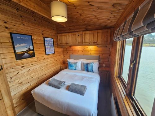a bedroom in a log cabin with two beds at Wroxham Broads Lodge Houseboat in Bellaghy