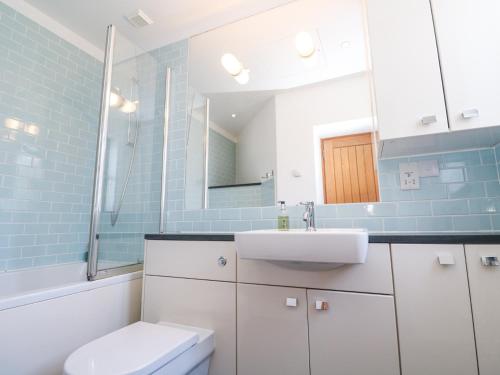 a bathroom with a sink and a toilet and a mirror at The Observatory Tower in Falmouth