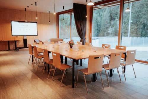 a large conference room with a large wooden table and chairs at Campra Alpine Lodge & Spa in Olivone