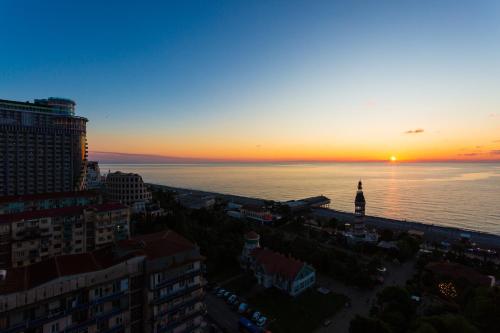 a sunset over the water in a city at ORBI City N9 HoTeL in Batumi