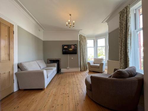 ein Wohnzimmer mit zwei Sofas und einem Kamin in der Unterkunft The 100 House - Llandudno in Llandudno