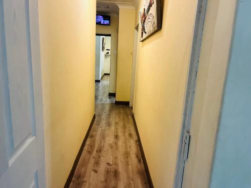 a hallway with yellow walls and a wooden floor at House 210 holiday rentals in Alberton