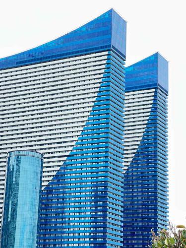 a large skyscraper with blue windows in a city at ORBI City N9 HoTeL in Batumi