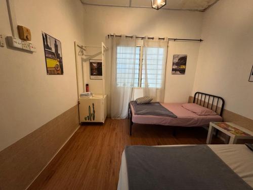a room with two beds and a window in it at Wi-Fi 100MB free Ipoh Town Holiday House Tmn Shatin S36 in Ipoh