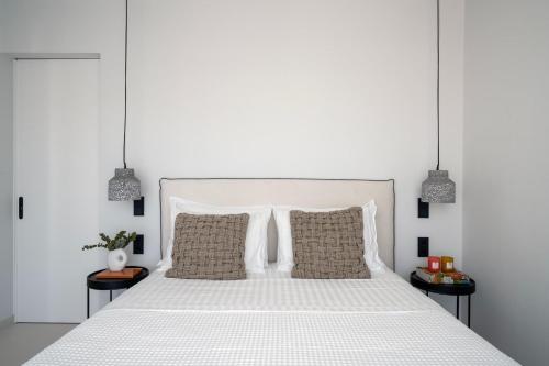 a bedroom with a white bed with two pillows at Marina Exclusive Apartment in Porto Heli