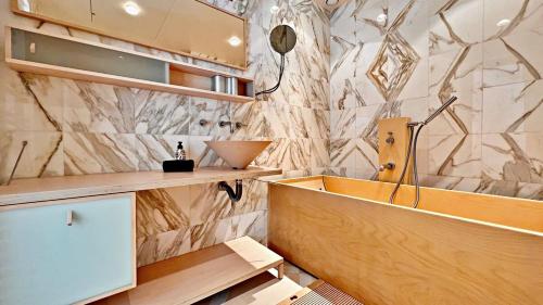 La salle de bains est pourvue d'une baignoire et d'un mur en marbre. dans l'établissement Palm & Sun, à Nice
