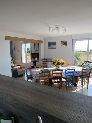 un salon avec une table et des chaises dans l'établissement L'Anse de Landemer Montfarville, à Montfarville