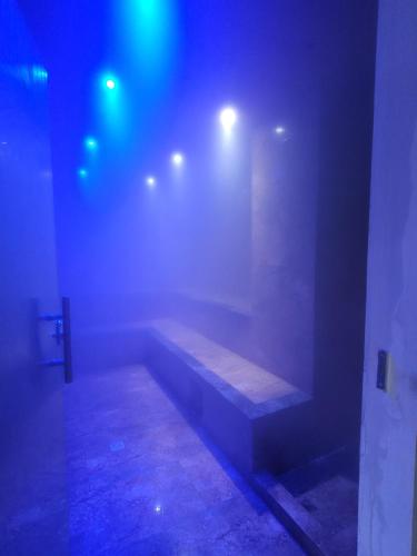 a dark room with a bench on a wall with lights at Mirador del Cielo Apart-hotel Boutique in Santa Cruz de la Sierra