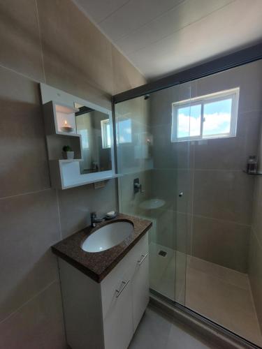 a bathroom with a sink and a glass shower at Mirador del Cielo Apart-hotel Boutique in Santa Cruz de la Sierra