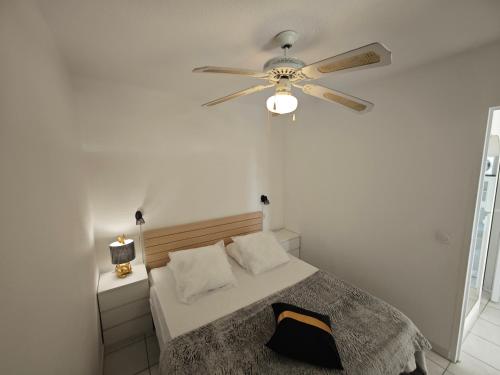 une chambre avec un lit avec un ventilateur de plafond dans l'établissement Appartement Village Naturiste Concupiscence, au Cap d'Agde