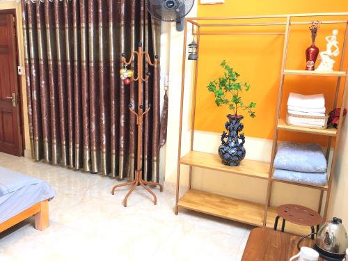 a room with a bed and a shelf with a plant at Gia Bảo Homestay - Cao Bằng in Cao Bằng