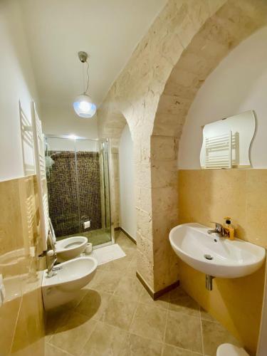 a bathroom with two sinks and two toilets at Rifugio Rosa in Castellana Grotte