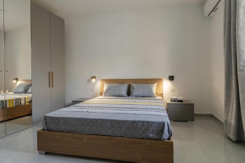 a bedroom with a large bed with a wooden headboard at 2 bedroom bright apartment in Gudja
