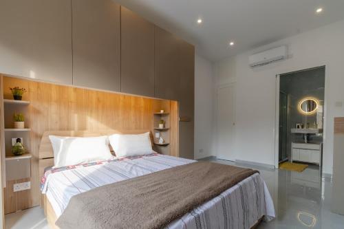 a bedroom with a large bed with a wooden headboard at 2 bedroom bright apartment in Gudja