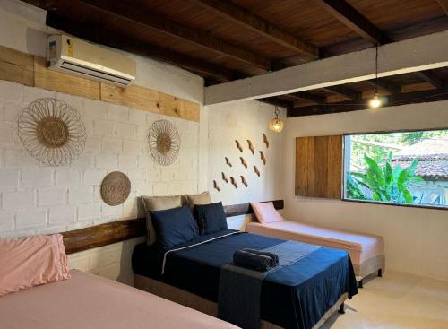a bedroom with two beds and a window at Igapeba Hospedaria em Moreré in Cairu