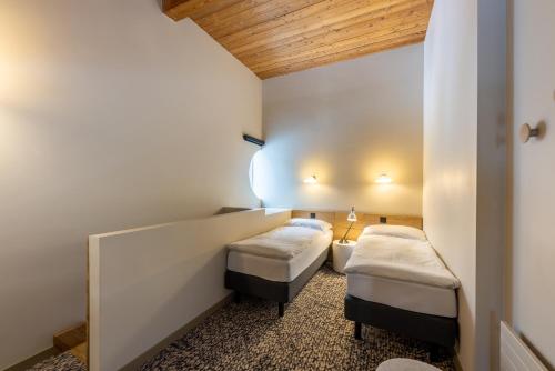 a room with two beds in a room at Hotel Schweizerhof Sils Maria, a Faern Collection Hotel in Sils Maria