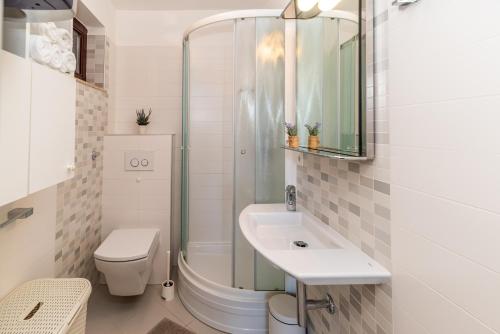 a bathroom with a shower and a toilet and a sink at Biserka 2 with stunning sea view in Punat