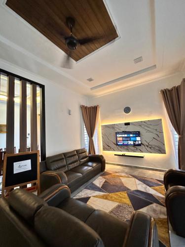 a living room with a couch and a flat screen tv at Homestay Husna in Dungun