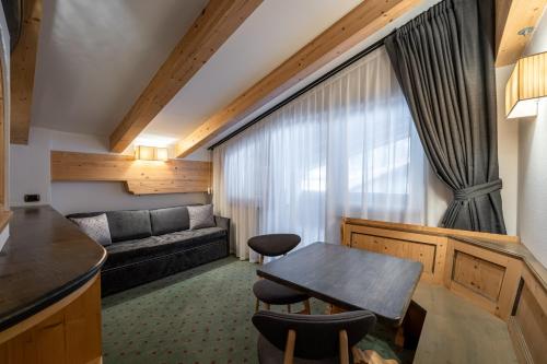 a living room with a table and a couch at Croce Bianca Leisure & Spa Hotel in Canazei