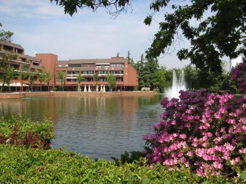 a pond in front of a building with a fountain at Casa Vacanze Tigli 312 in Basiglio