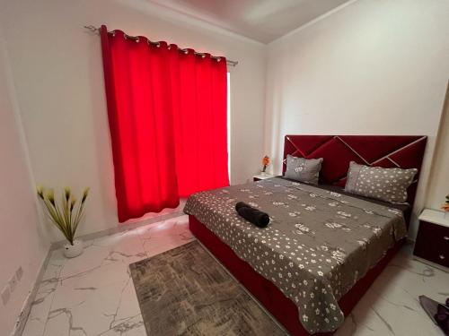 a bedroom with a red curtain and a bed at Oasis tower family apartment 2302 in Ajman 