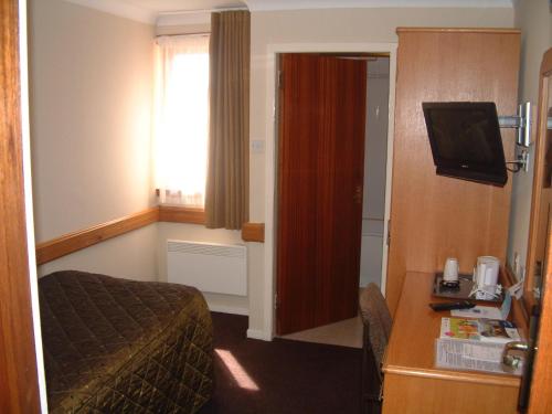 a hotel room with a bed and a television at Best Western Kings Manor in Edinburgh