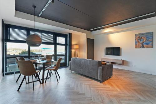 a living room with a couch and a table and chairs at Dock Hotel Stellendam in Stellendam