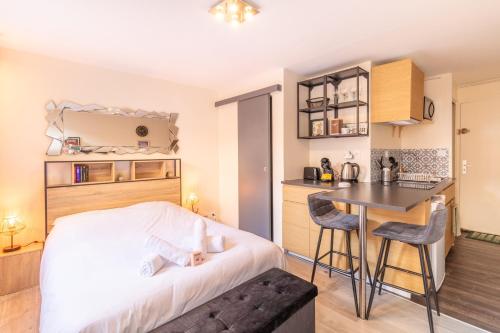 une chambre avec un lit et une table et une cuisine dans l'établissement Le cocon Toulousain, à Toulouse