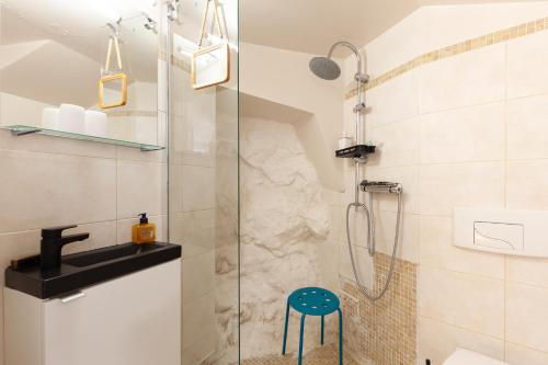 La salle de bains est pourvue d'une douche et d'un tabouret bleu. dans l'établissement I Feel Goudes, à Marseille