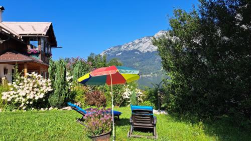 a table and two chairs and an umbrella in a yard at Haus Seegarten - LANDLUFT in Grundlsee