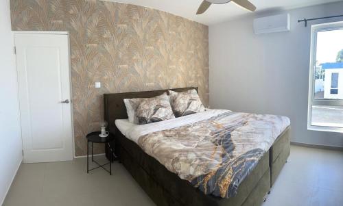 Un dormitorio con una cama y una pared. en The luxury flamingo, en Willemstad