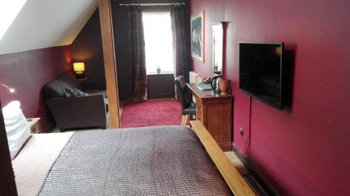 a hotel room with a bed and a tv on the wall at Lime Tree Hotel in Fort William